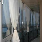 Белые итальянские шторы на лоджию с панорамными окнами